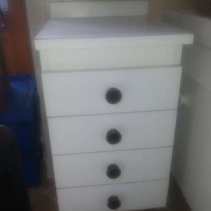 Cucina bianca con tavolo, sedie, macchina a gas